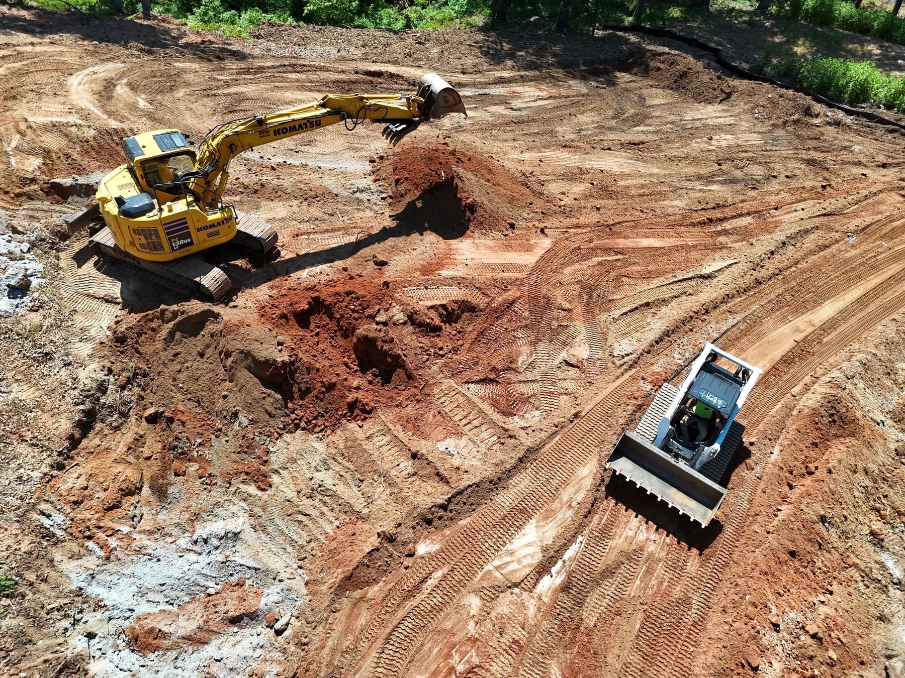 Excavator and compact loader preparing a home site